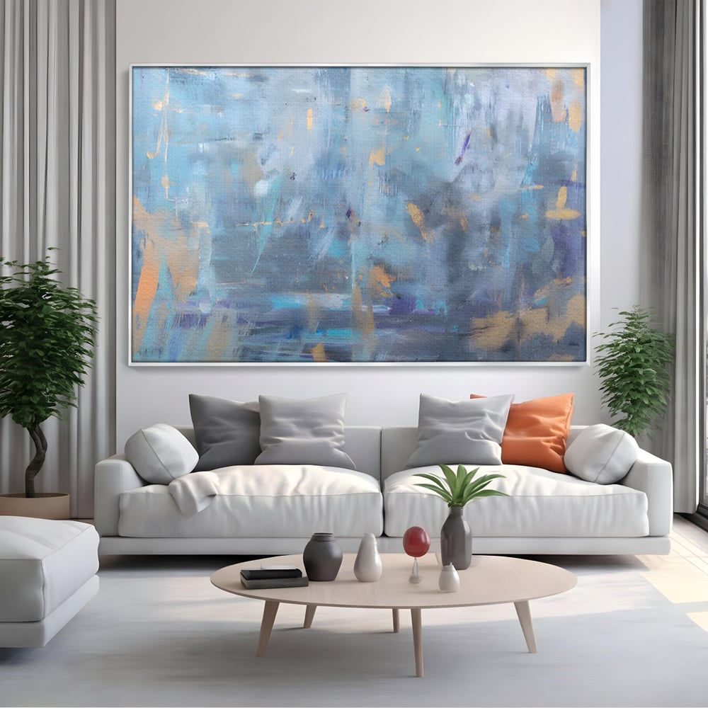Tablou canvas cu pictura abstracta cu pete aurii si albastre, in rama de aluminiu argintiu, pe perete intr-un living